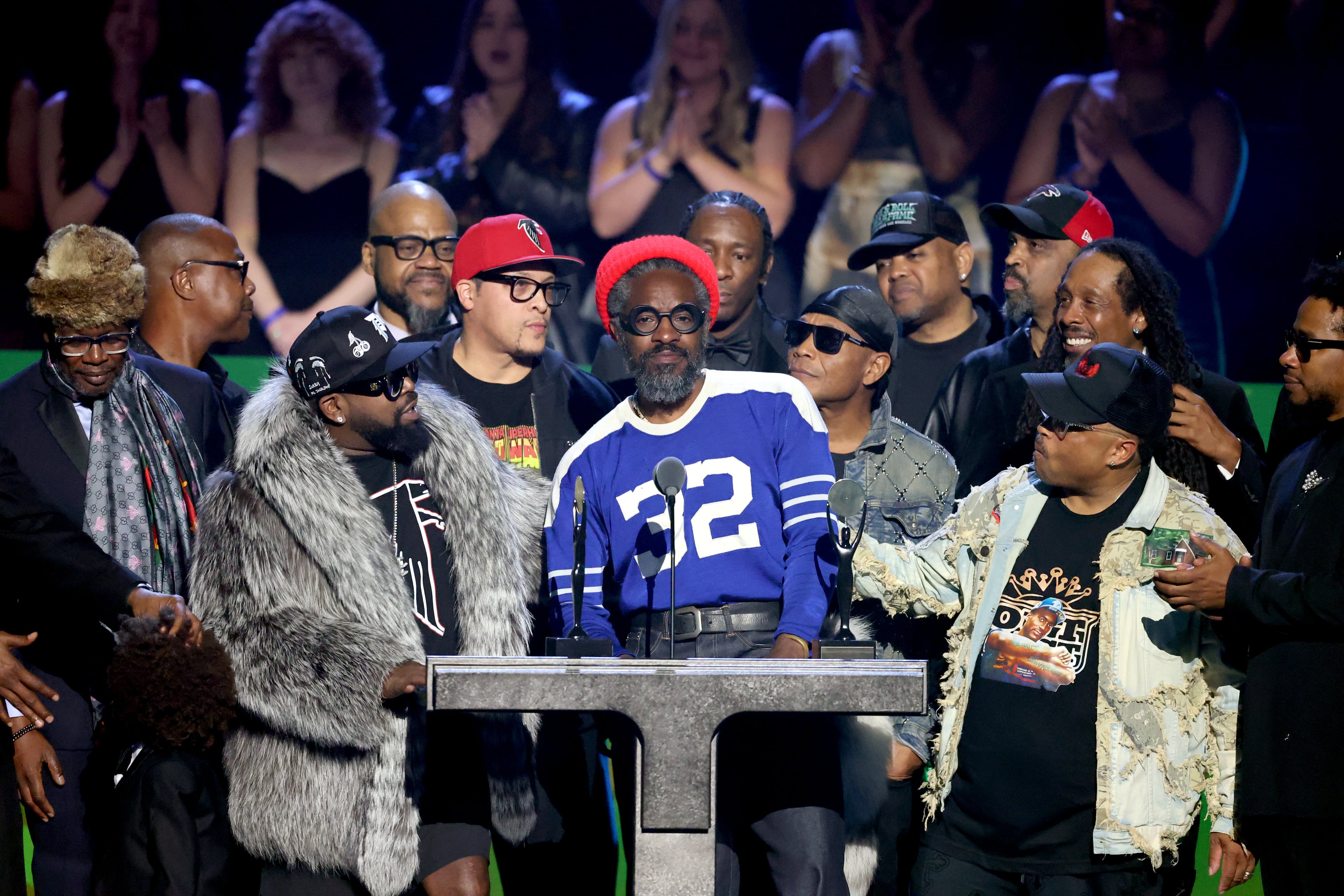 Inductees André 3000 of OutKast, center, grow emotional as he talks about the path from small rooms to big stages, while surrounded by Big Boi and a group of Atlanta friends and family during the 2025 Rock & Roll Hall of Fame Induction Ceremony. (Photo by Amy Sussman/WireImage)
