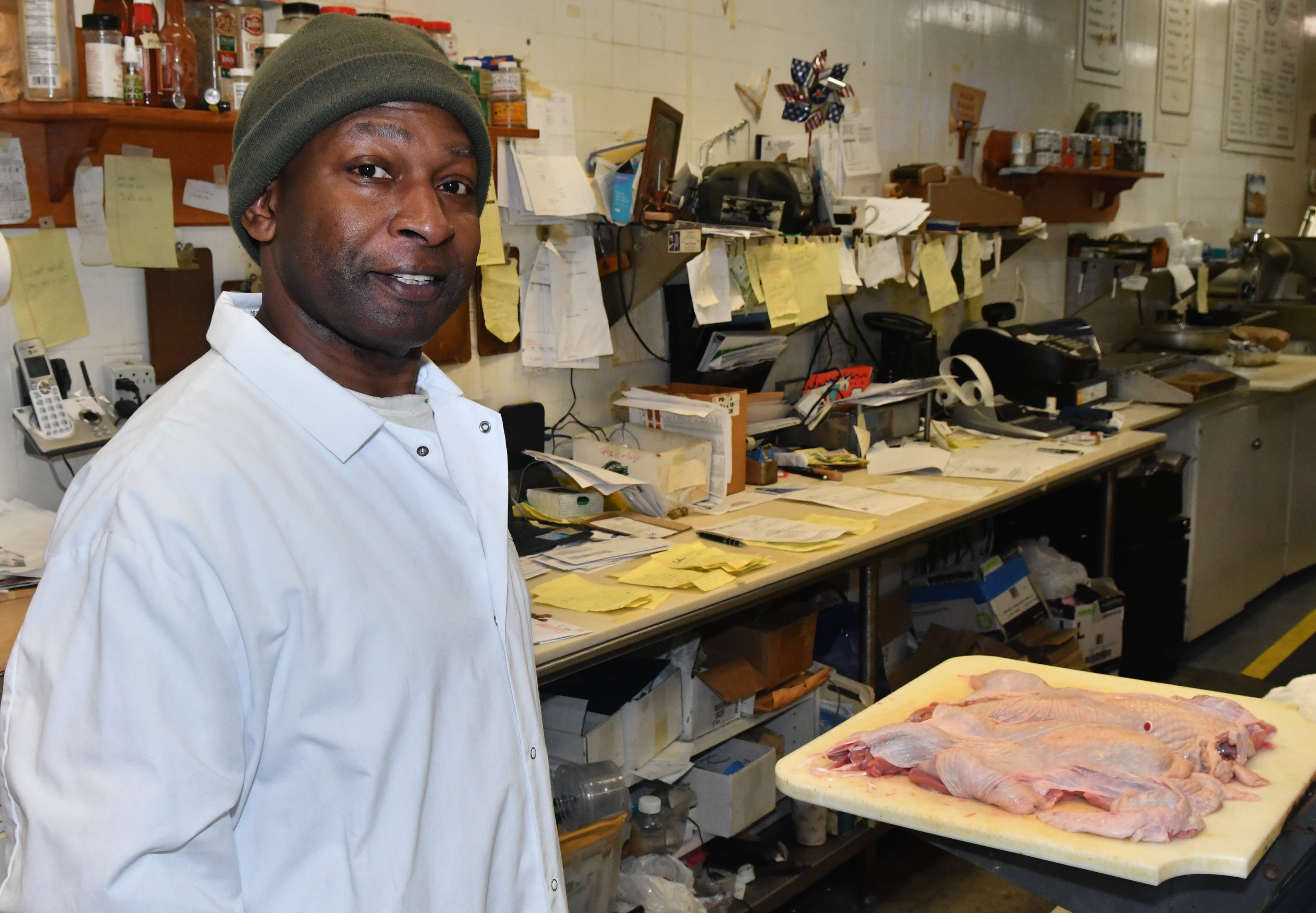 231120 Atlanta, Ga: Diamond Mardell, owner and operator of ShieldÕs Meat Market poses in his work area. Mardell says every one of those yellow slips of paper on the table behind him is an order. Mardell is a sole operator on all but his busiest days of the year, Mardell says, ÒitÕs a lot of work, but itÕs OK - because I know I can do the work of 3 peopleÓ. Photo for use in AJC Made In Georgia column by CW Cameron. The AJC visits ShieldÕs Meat Market, a seventy-six year old business started in downtown Decatur and now operating in the Emory Village business district, 1544 N.Decatur Road, Suite B, Atlanta, Ga. 30307. Owner and proprietor Diamond Mardell will be the guide for the tour. (CHRIS HUNT FOR THE ATLANTA JOURNAL-CONSTITUTION)