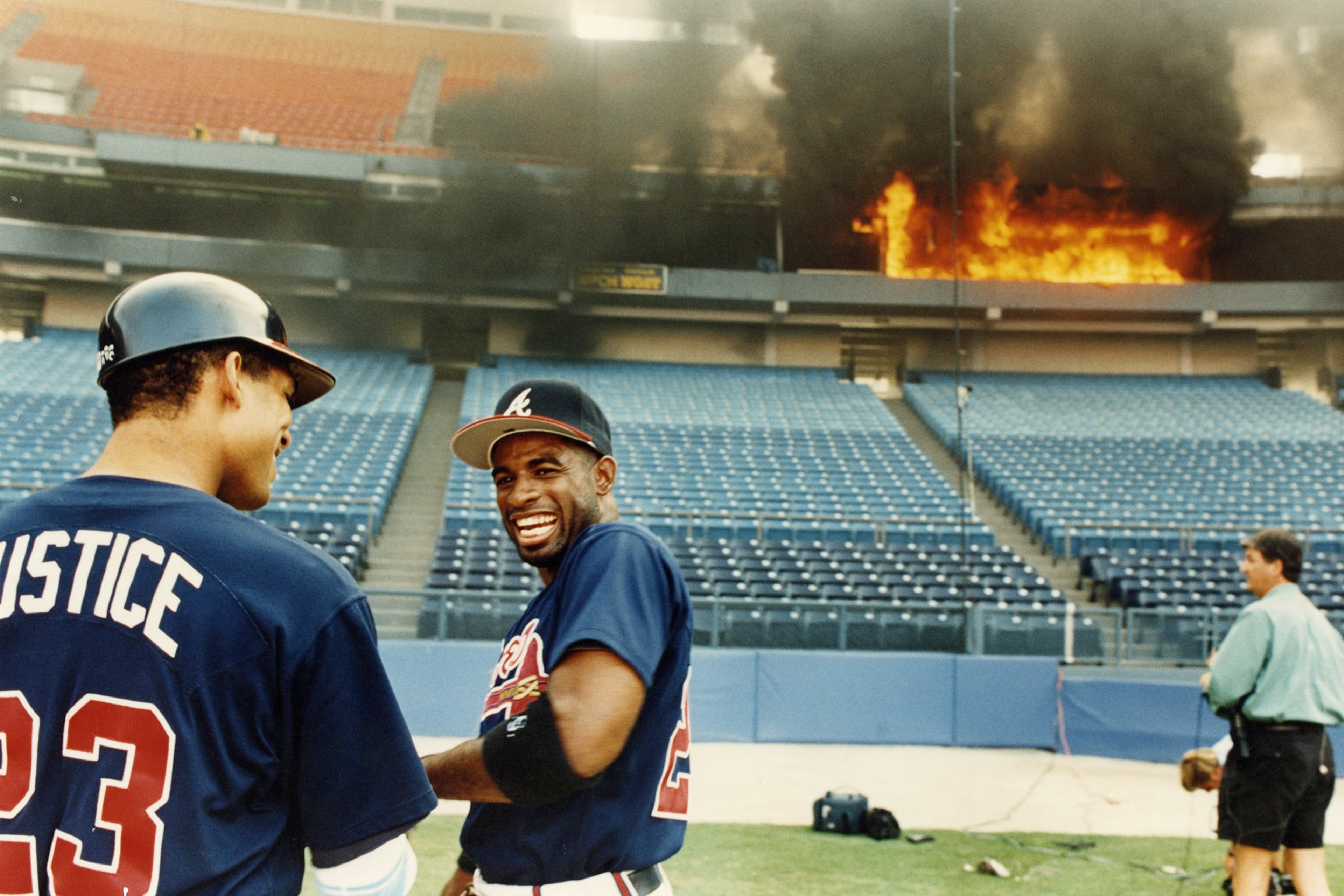 Atlanta Braves players David Justice (left) and Deion Sanders clown around as a fire burns at Atlanta-Fulton County Stadium in 1993. (John Kuntz for the AJC)