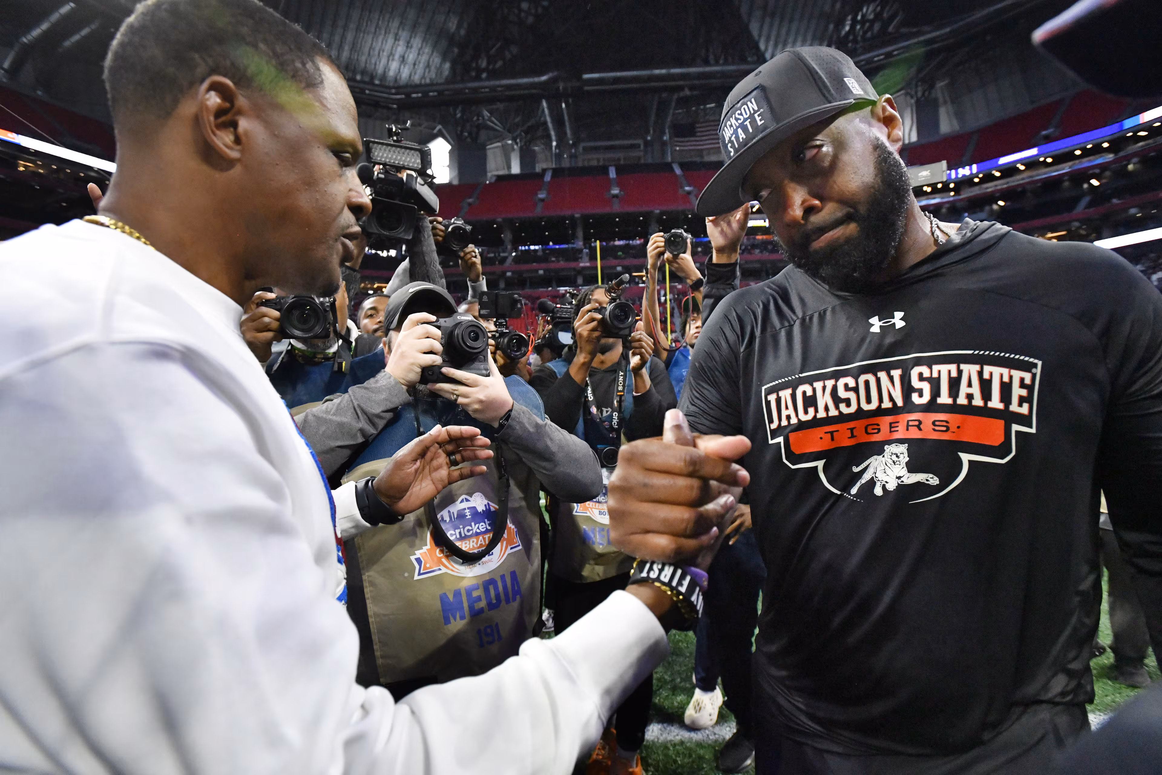 South Carolina State head coach Chennis Berry and Jackson State head coach T.C. Taylor shake hands after Jackson State won last year's Cricket Celebration Bowl. (Hyosub Shin/AJC 2024)