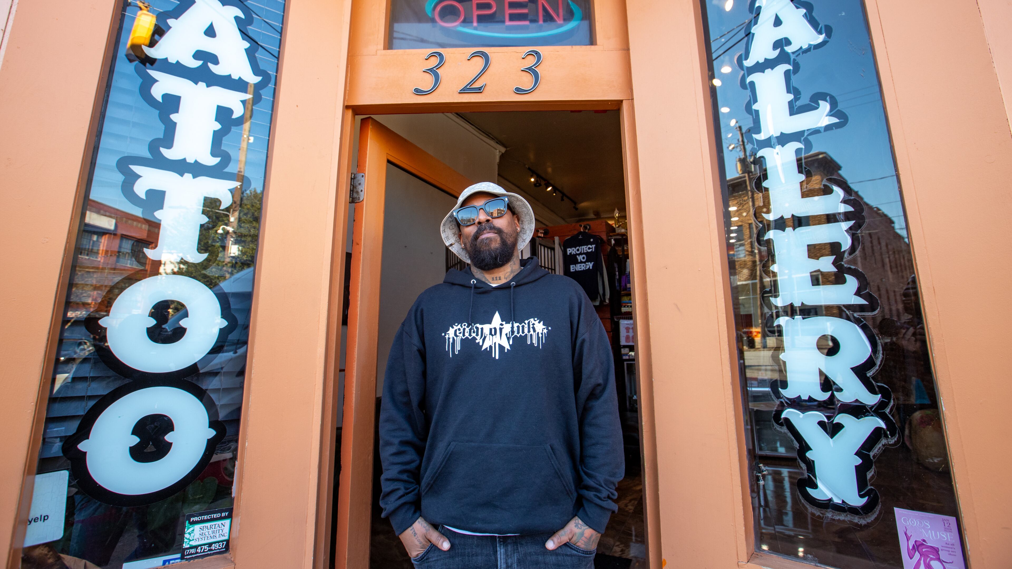 Miya Bailey stands in front of City of Ink on Walker Street in 2024. He received massive public support when he shared that his tattoo shop was at risk of closure due to an ordinance banning new tattoo parlors in Castleberry Hill, an ordinance that was enacted a year after his shop opened. (Jenni Girtman for the AJC)