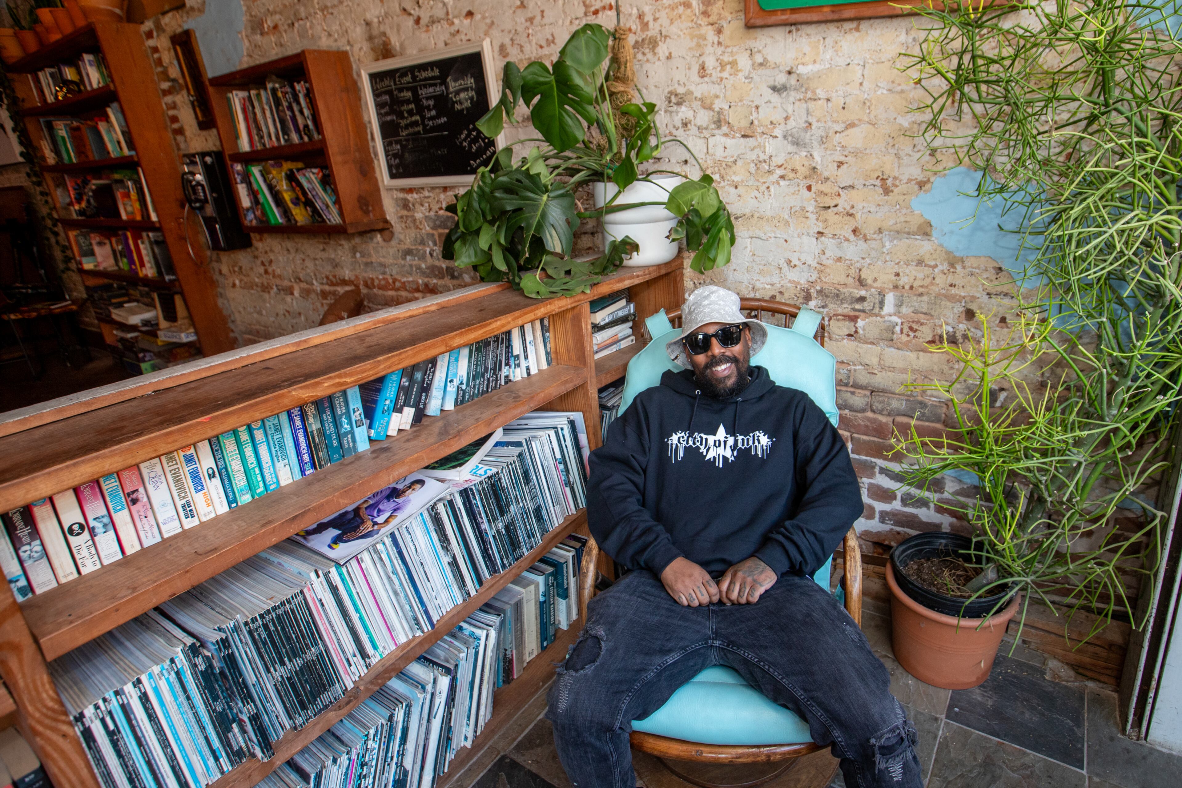 Miya Bailey relaxes at Peters Street Station, a community center and coffee shop with a back room art gallery on Walker Street. Bailey, who also owns City of Ink on the same block, is the entrepreneur, tattoo artist and property owner who continues to be a creative inspiration for the community. (Jenni Girtman for the AJC 2024)