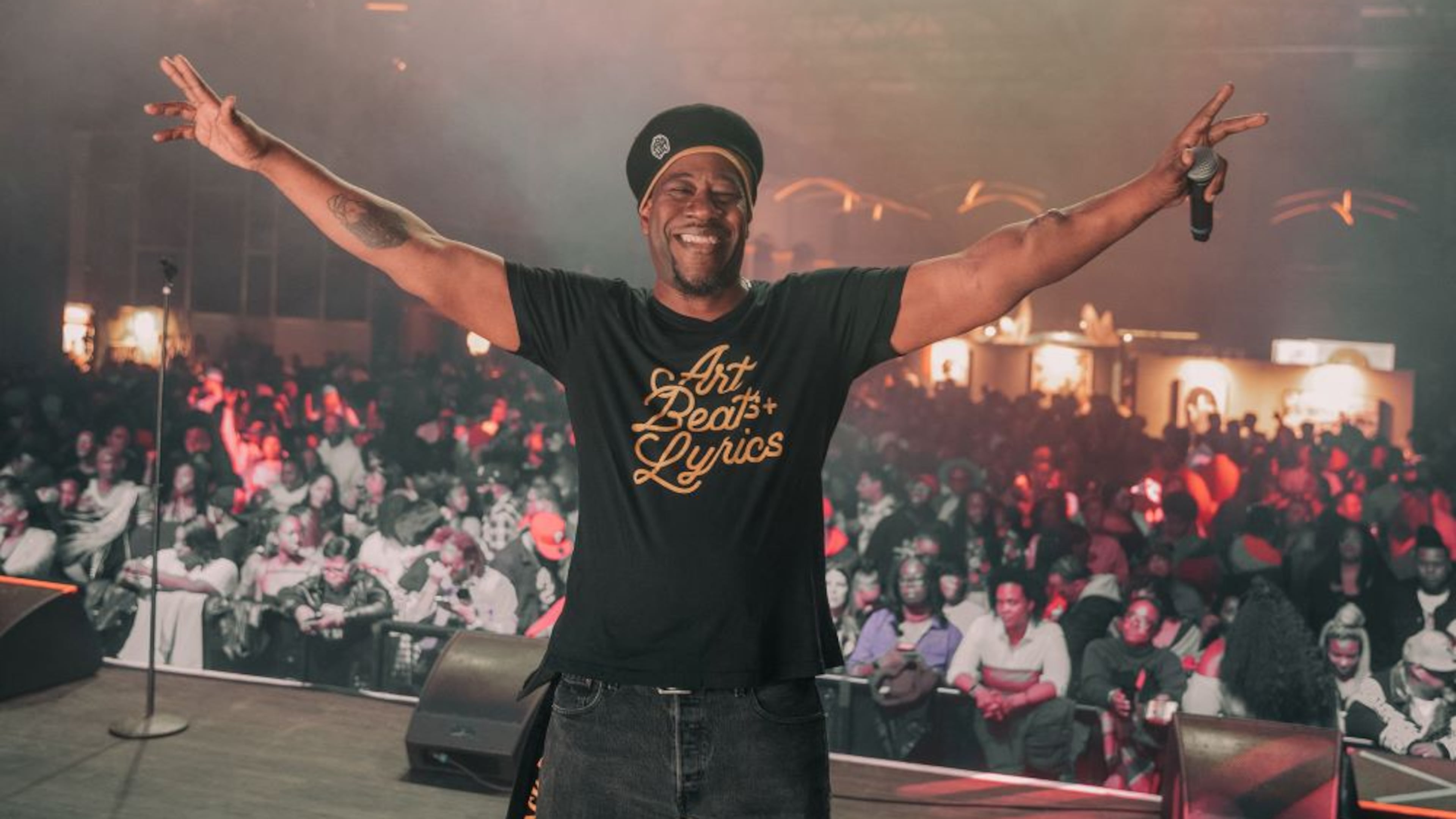 Event host and beatboxer Andre "D.R.E.S. Tha Beatnik" Lett poses for a pic in front of the audience at Arts Beats + Lyrics, a traveling art and hip-hop show, in Chicago in 2023. D.R.E.S. died June 9 after a yearslong battle with kidney disease. (Courtesy of Kat Goduco)