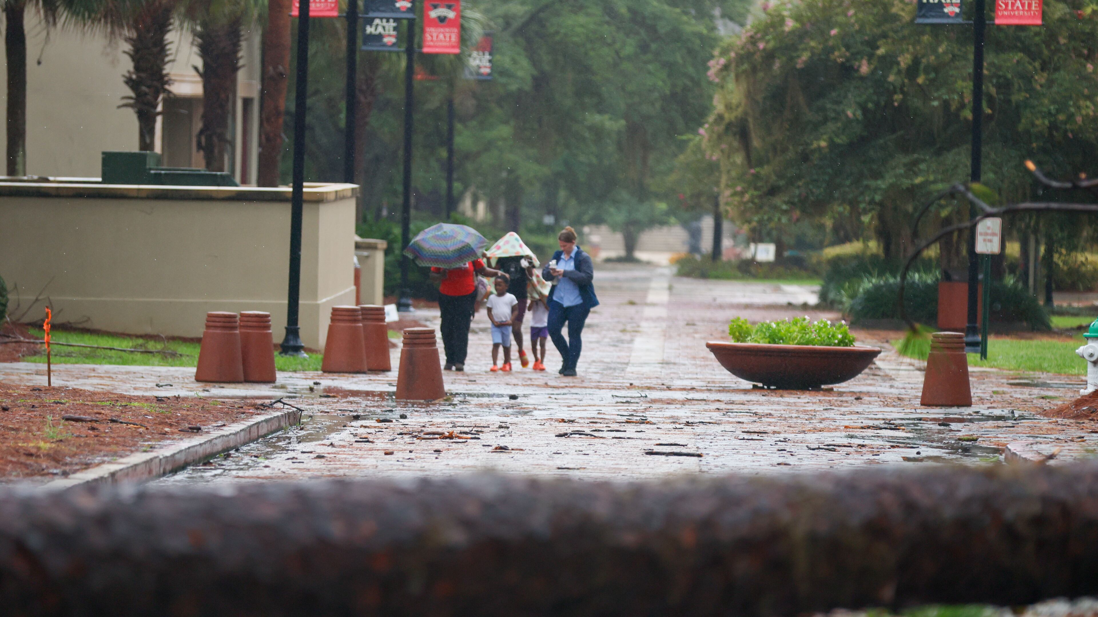 People were seen walking through the Valdosta State University campus on Monday, Aug. 5, 2024, in the aftermath of Hurricane Debby. (Miguel Martinez/AJC)