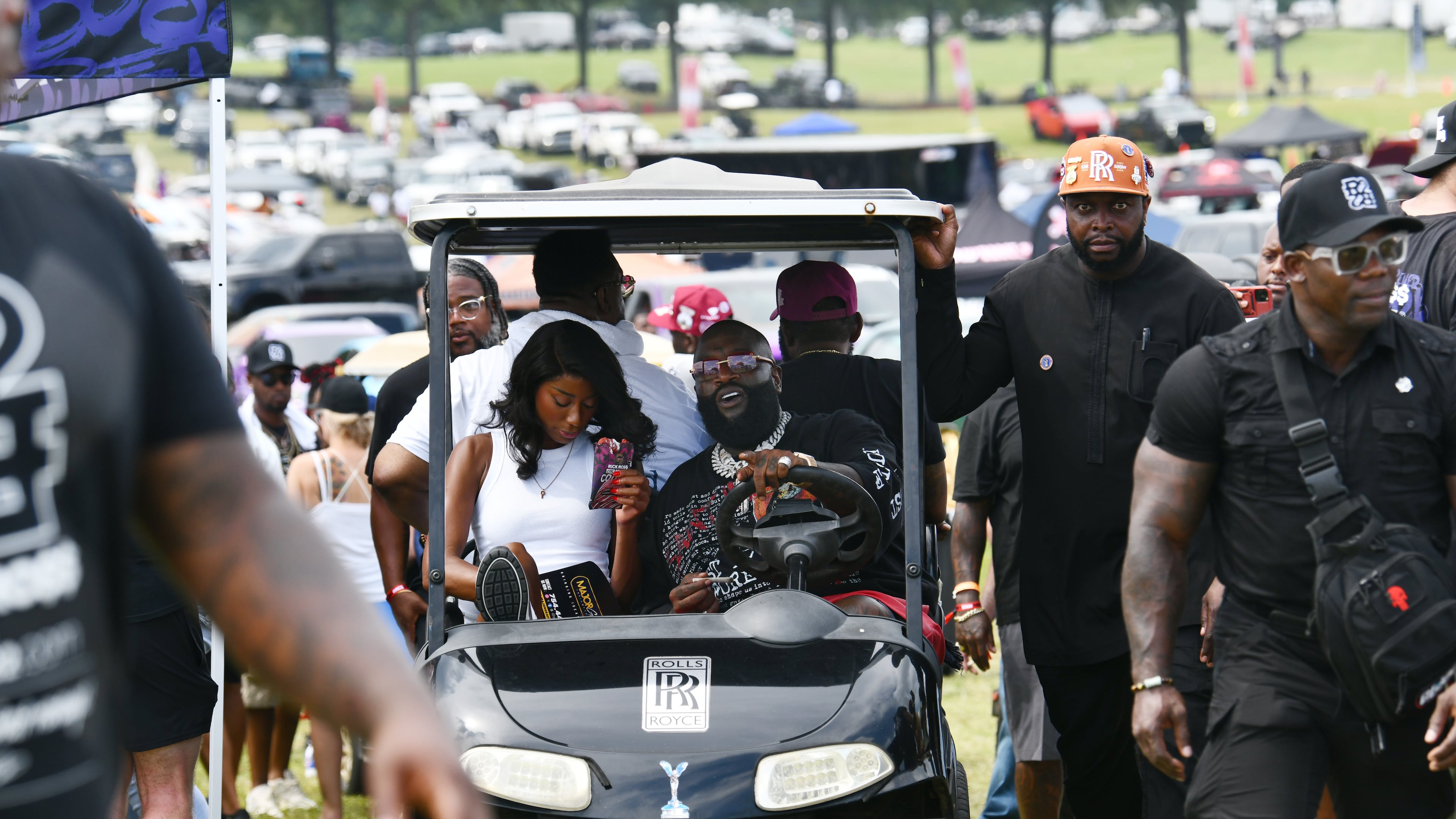 Rick Ross drives his golf cart around the Rick Ross Car Show on Saturday at the Promise Land, his mansion in Fayetteville. The car show included a market with more than 30 vendors, food trucks, fleets of classic/custom automobiles, luxury vehicles, boats, RVs and trailers on the front lawn of the mansion. There were also performances by Plies, Ross' new signee, Nino Breeze, and Ross himself. (Hyosub Shin/AJC)