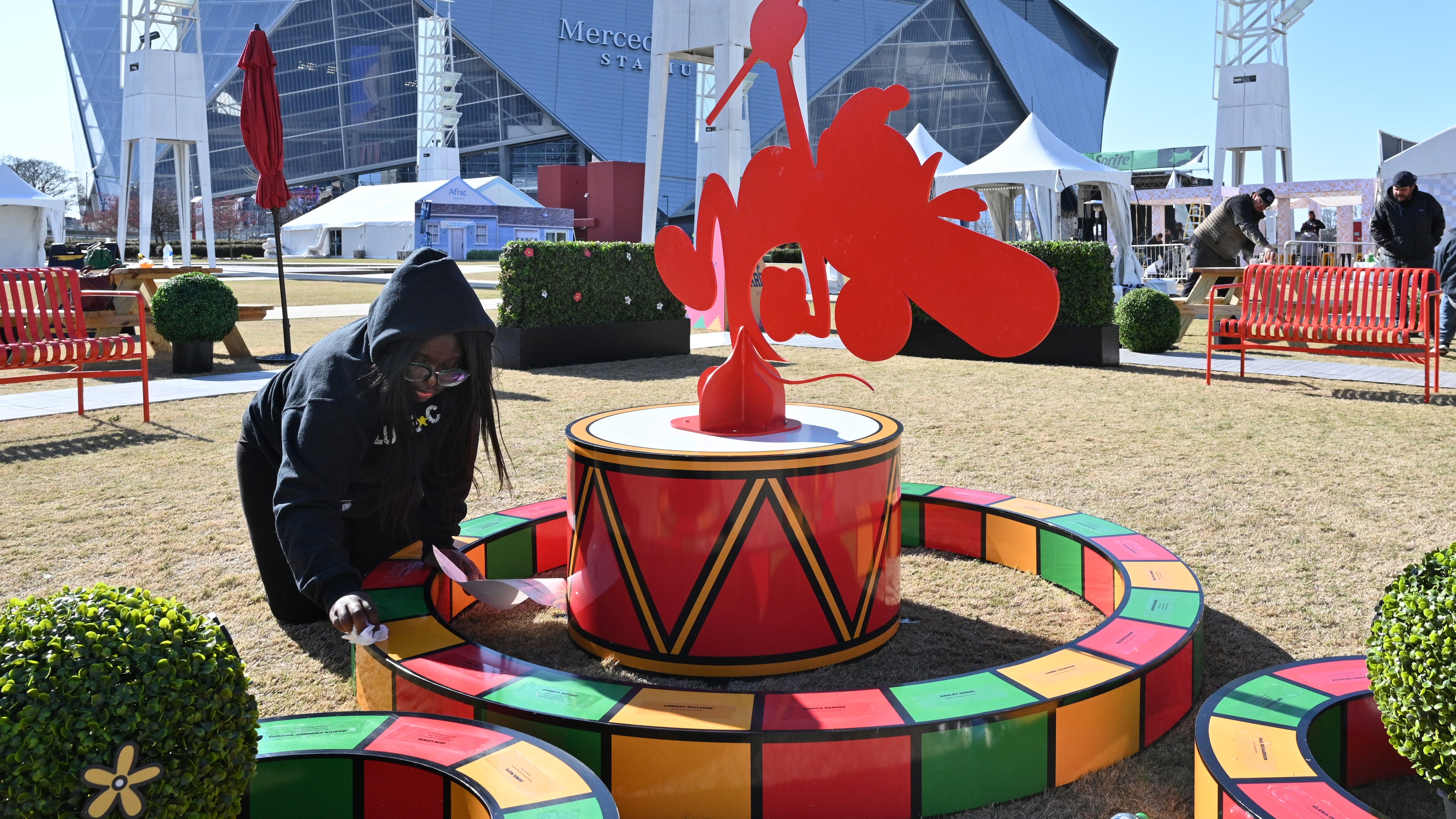 Imani Lunda puts the finishing touches at the Coca-Cola Fan Experience at the Georgia World Congress Center International Plaza ahead of the Cricket Celebration Bowl in December 2022. The Coca-Cola Fan Experience this year will be Saturday in Hall C at the Georgia World Congress Center. (Hyosub Shin/AJC 2022)